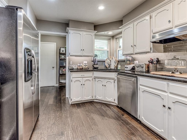 kitchen with dark countertops, white cabinetry, and stainless steel appliances