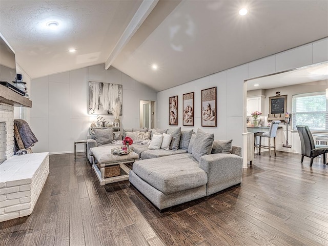 living area with dark wood-style floors, lofted ceiling with beams, and a brick fireplace