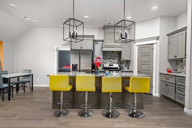 kitchen featuring stainless steel appliances, visible vents, gray cabinetry, and tasteful backsplash