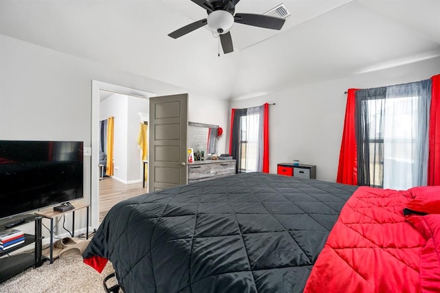 bedroom with lofted ceiling, wood finished floors, visible vents, baseboards, and a ceiling fan