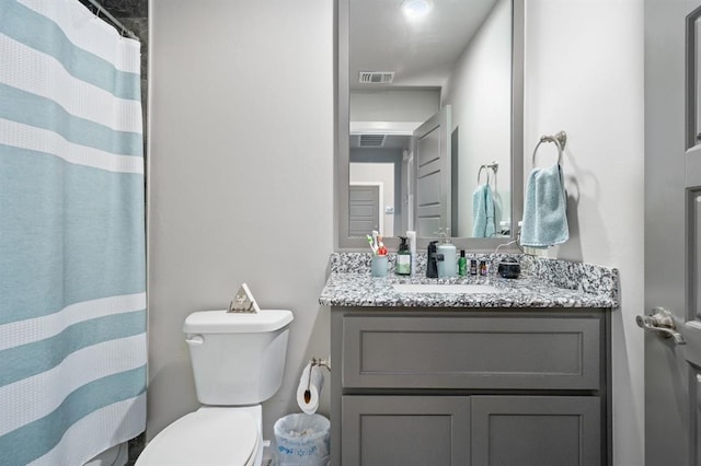 bathroom featuring toilet, curtained shower, visible vents, and vanity