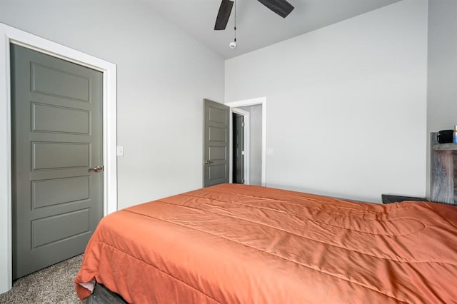 carpeted bedroom featuring lofted ceiling and a ceiling fan