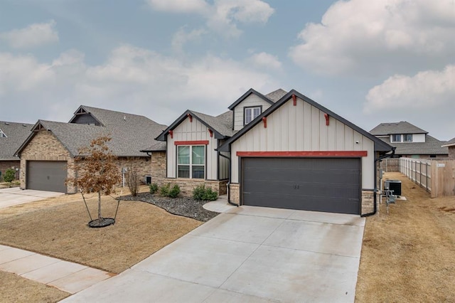 craftsman-style home featuring an attached garage, central air condition unit, fence, concrete driveway, and board and batten siding