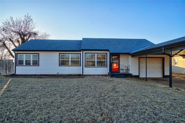 view of front facade with a garage, a front yard, roof with shingles, and fence