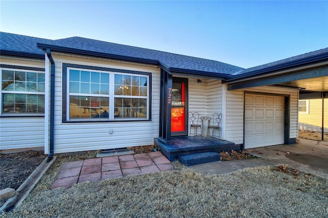 view of front of property featuring concrete driveway, roof with shingles, and an attached garage