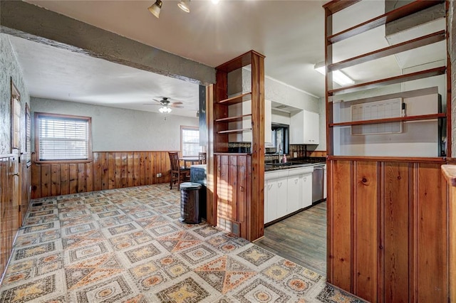 kitchen featuring wooden walls, white cabinets, wainscoting, dishwasher, and open shelves