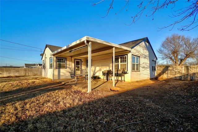 view of front facade with a patio area and fence