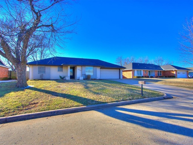 ranch-style home featuring concrete driveway, a front lawn, and an attached garage