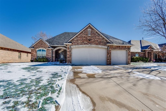 view of front of home featuring a garage, a shingled roof, concrete driveway, and brick siding