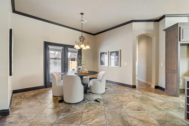 dining room featuring baseboards, visible vents, arched walkways, ornamental molding, and french doors