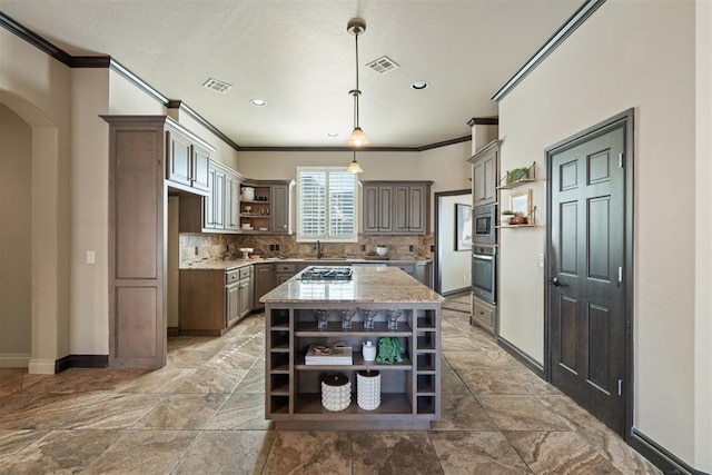 kitchen with visible vents, hanging light fixtures, light countertops, a center island, and open shelves