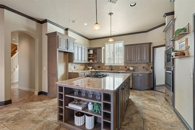 kitchen featuring open shelves, visible vents, hanging light fixtures, appliances with stainless steel finishes, and a kitchen island