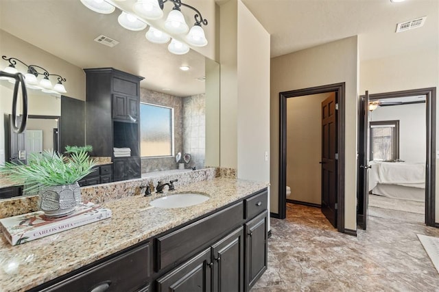 bathroom with toilet, vanity, visible vents, and baseboards