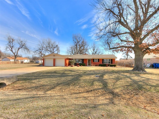 ranch-style house featuring an attached garage, concrete driveway, and a front yard