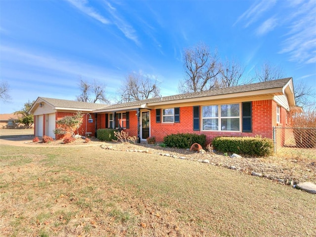 ranch-style home with an attached garage, a front yard, fence, and brick siding