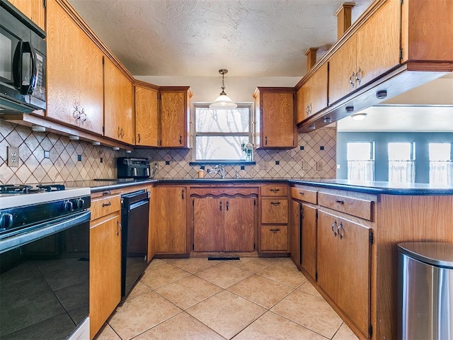 kitchen with dark countertops, black appliances, brown cabinetry, and decorative light fixtures