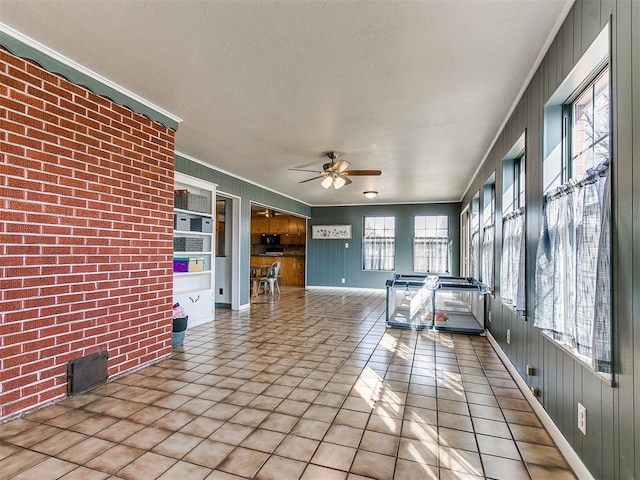 unfurnished sunroom featuring a ceiling fan