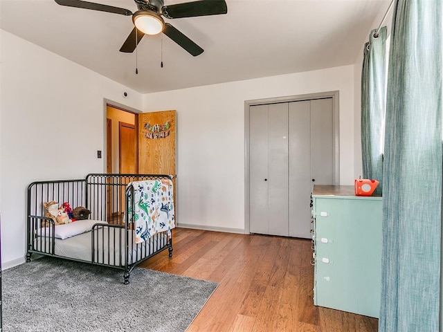 bedroom featuring light wood finished floors, baseboards, and a ceiling fan