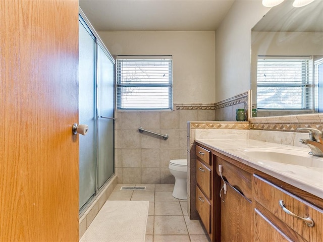 full bathroom featuring tile walls, vanity, visible vents, tile patterned floors, and a stall shower