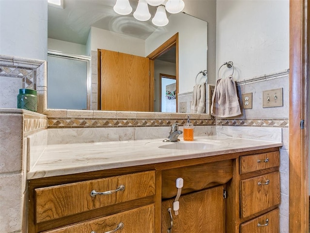 bathroom with a shower with door, decorative backsplash, and vanity