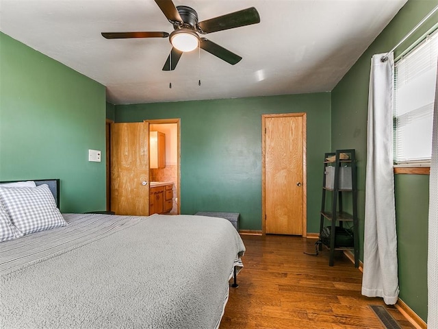 bedroom featuring ceiling fan, dark wood finished floors, visible vents, and baseboards