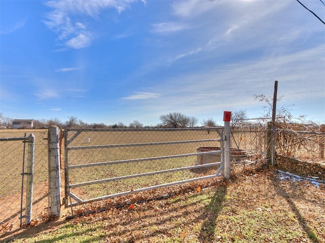 view of gate featuring a rural view and fence