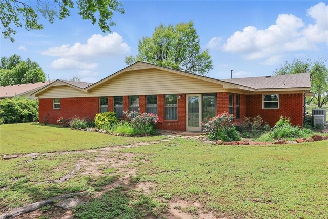 406 S Pine St, Crescent, OK 73028 - rear view of house featuring a lawn, central air condition unit, and brick siding