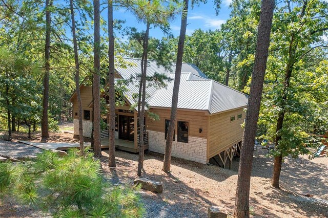 view of home's exterior featuring stone siding and metal roof