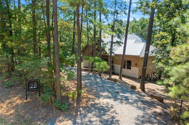 view of side of home with stone siding and metal roof