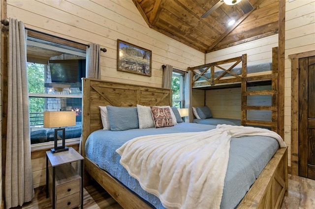 bedroom featuring vaulted ceiling, wooden ceiling, wood finished floors, and wooden walls