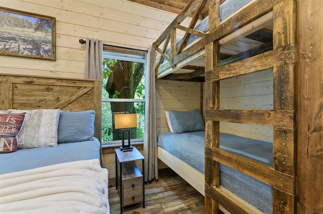 bedroom featuring dark wood-type flooring and wooden walls