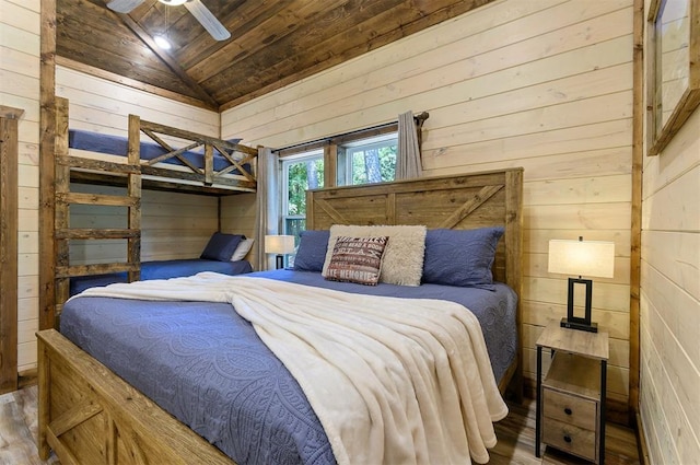 bedroom with vaulted ceiling, wood finished floors, wood ceiling, and wooden walls