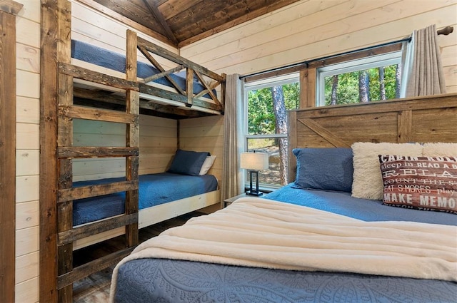 bedroom with lofted ceiling and wooden walls