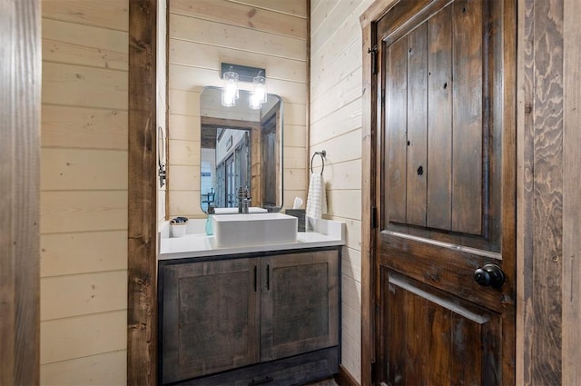 half bath featuring wood walls and vanity