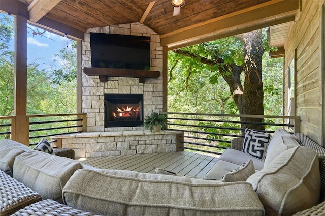 view of patio / terrace with ceiling fan and an outdoor living space with a fireplace