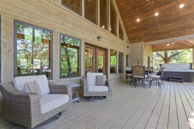 deck featuring outdoor dining space and a hot tub