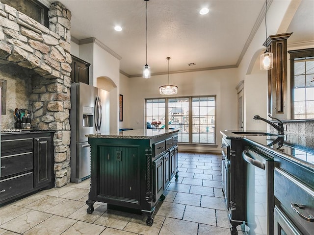 kitchen with arched walkways, a kitchen island, appliances with stainless steel finishes, dark stone countertops, and hanging light fixtures