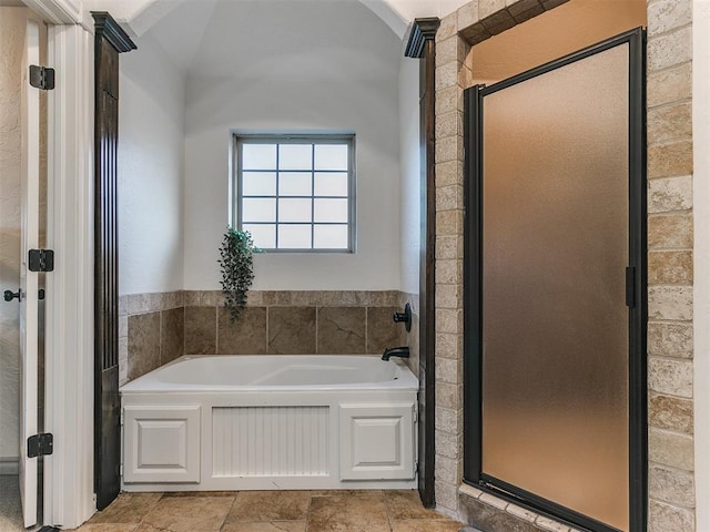 full bathroom with a shower stall and a bath