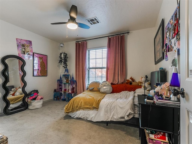 bedroom featuring carpet, visible vents, ceiling fan, and a textured ceiling