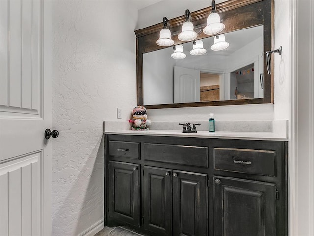 bathroom featuring a textured wall and vanity