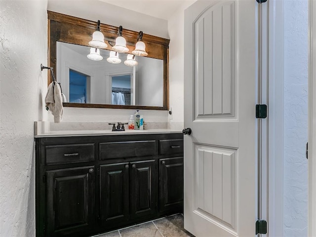 bathroom with a textured wall and vanity