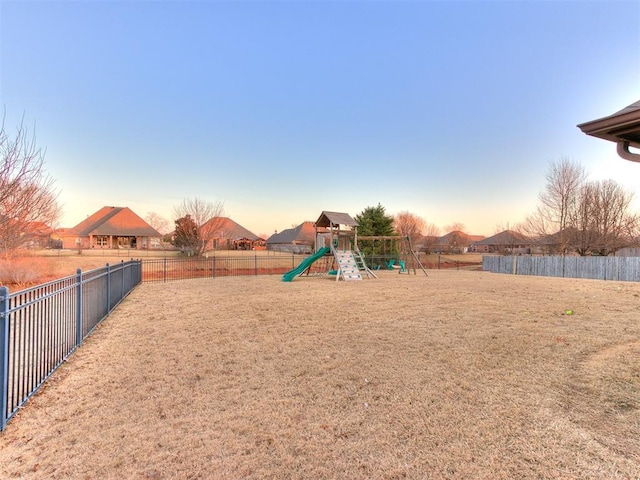 playground at dusk featuring a playground and fence