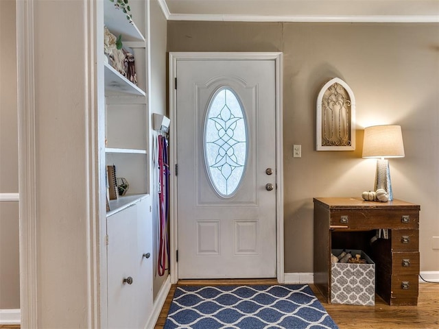 entryway with ornamental molding, baseboards, and wood finished floors