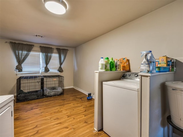 washroom featuring light wood-style floors, laundry area, visible vents, and baseboards