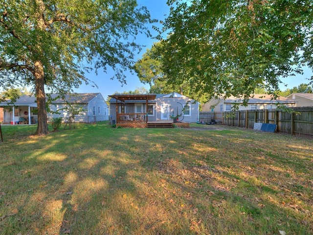 view of yard featuring a fenced backyard, a wooden deck, and a residential view