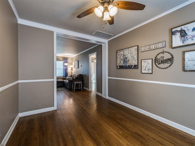 empty room with ceiling fan, visible vents, baseboards, dark wood-style floors, and crown molding