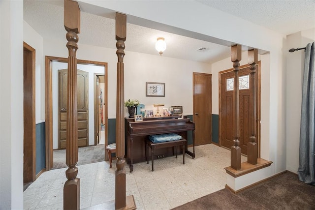 foyer with a textured ceiling and light carpet