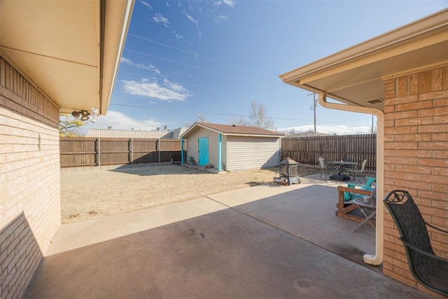 view of patio with an outbuilding, a fenced backyard, outdoor dining space, and a shed