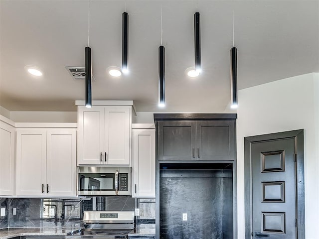 4419 Meadowpark Dr, Midwest City, OK 73110 - kitchen featuring white cabinetry, appliances with stainless steel finishes, visible vents, and backsplash