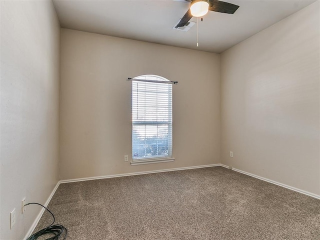 spare room with carpet, visible vents, ceiling fan, and baseboards